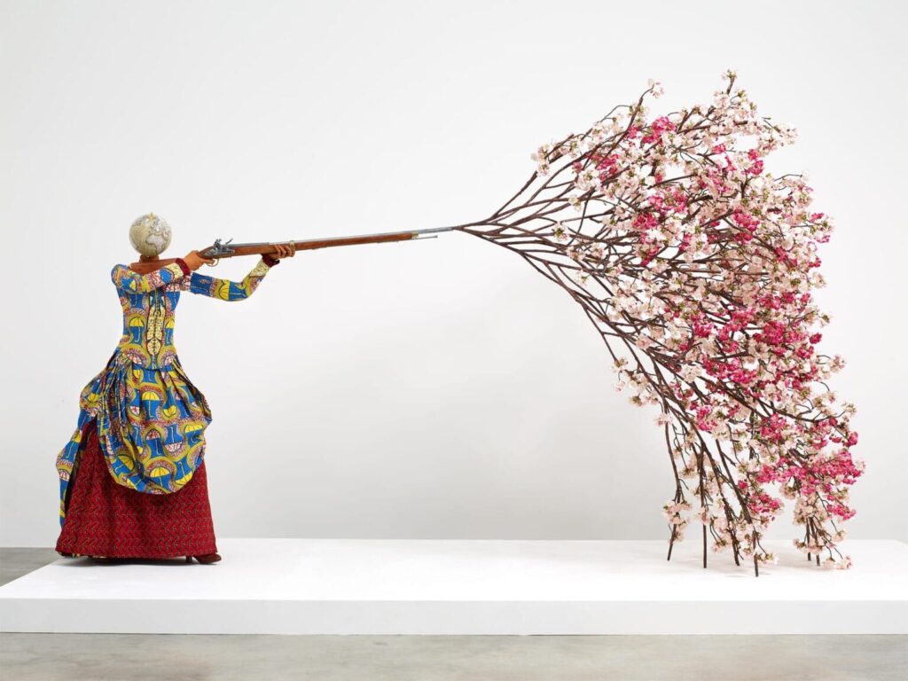 **Yinka Shonibare** - Suas obras abordam identidade, colonialismo e globalização, usando tecidos africanos coloridos para explorar diferenças culturais complexas.